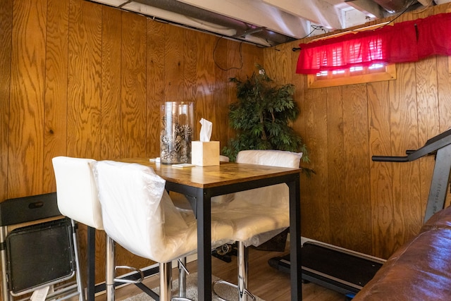 dining area featuring wooden walls and wood finished floors
