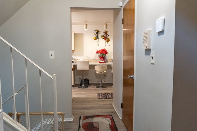 foyer entrance featuring baseboards, stairs, and wood finished floors