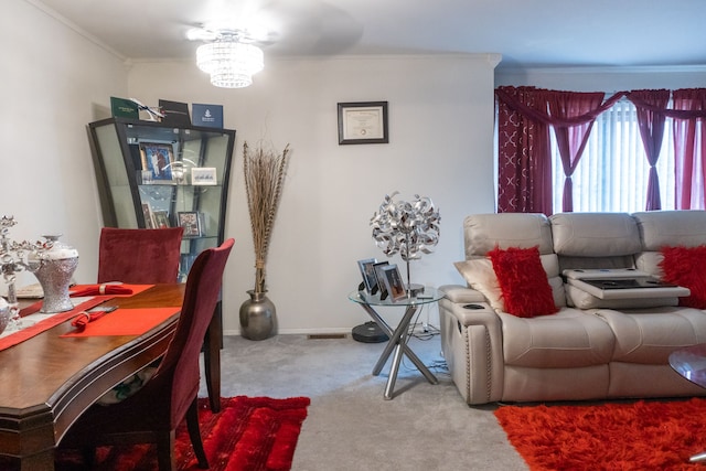 carpeted living room with baseboards, ornamental molding, and a chandelier