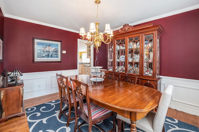 1615 Royal Birkdale Dr, Oxford, MI 48371 - dining area featuring a wainscoted wall, ornamental molding, wood finished floors, and an inviting chandelier