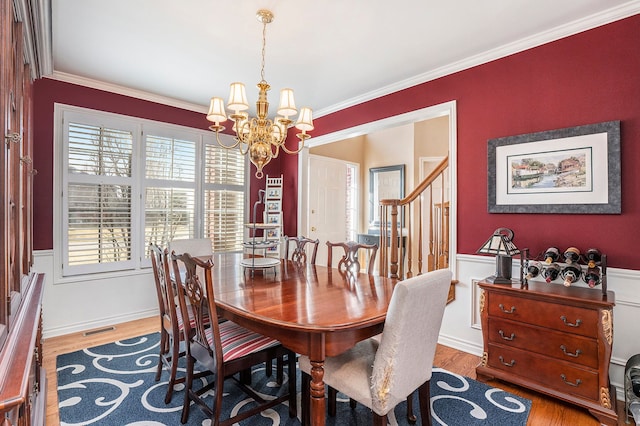 1615 Royal Birkdale Dr, Oxford, MI 48371 - dining room featuring stairway, ornamental molding, visible vents, a notable chandelier, and wood finished floors