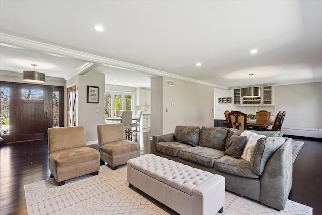 living room with crown molding, visible vents, recessed lighting, light wood-type flooring, and a baseboard heating unit