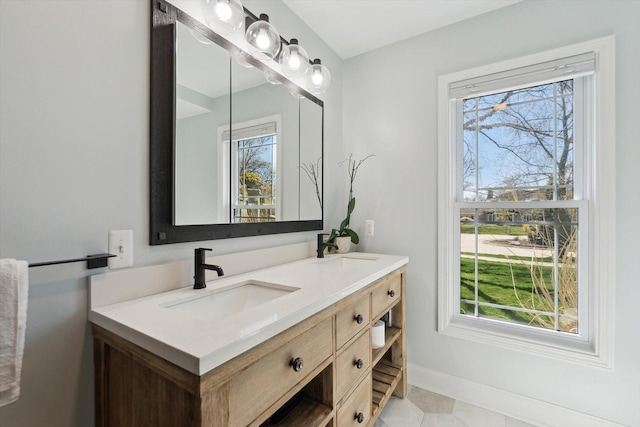 full bath featuring a sink, baseboards, and double vanity