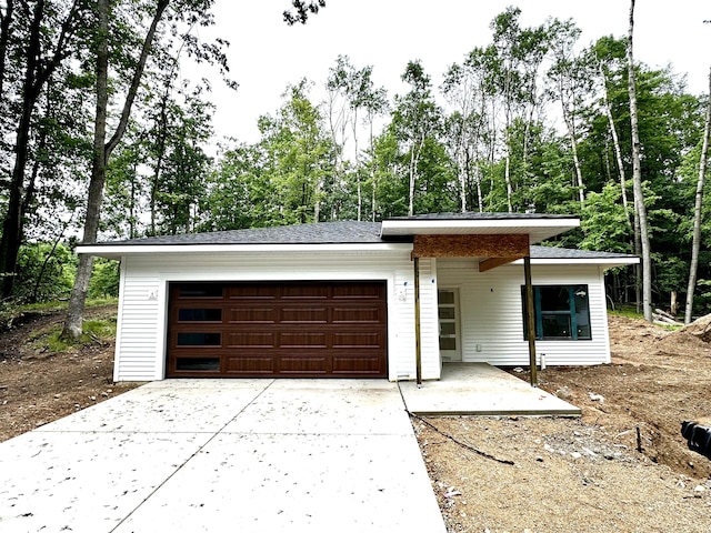 11300 Apache Wells Ct, Stanwood, MI 49346 - view of front of home with driveway, an attached garage, and view of scattered trees