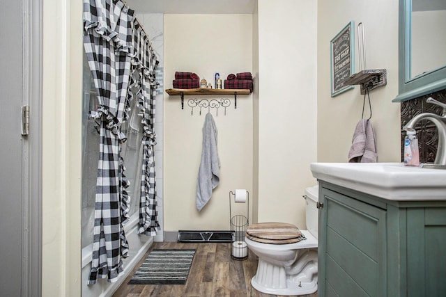 771 Q Dr S, Fulton, MI 49052 - bathroom featuring toilet, wood finished floors, vanity, and shower / bath combo with shower curtain