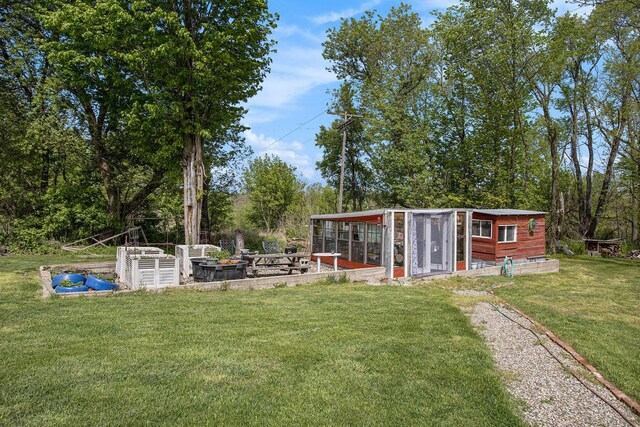 771 Q Dr S, Fulton, MI 49052 - view of green lawn featuring a garden, exterior structure, an outdoor structure, and view of wooded area