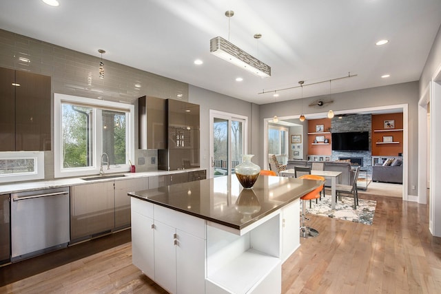 1686 Traceky, Rochester Hills, MI 48306 - kitchen with stainless steel dishwasher, a sink, light wood-type flooring, tasteful backsplash, and a fireplace