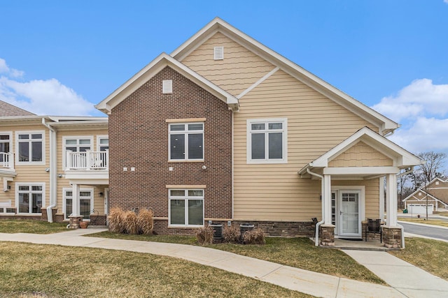 616 Boardwalk Ln Unit 24, Dexter, MI 48130 - view of property with a balcony, cooling unit, a front yard, and brick siding