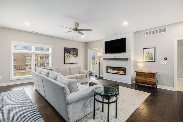 616 Boardwalk Ln Unit 24, Dexter, MI 48130 - living room featuring dark wood-type flooring, baseboards, a large fireplace, ceiling fan, and visible vents