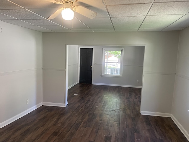 1776 Mcilwrath St, Muskegon, MI 49442 - spare room featuring dark wood-style flooring, baseboards, a ceiling fan, and a paneled ceiling