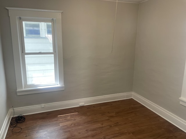 1776 Mcilwrath St, Muskegon, MI 49442 - spare room featuring baseboards and dark wood-type flooring