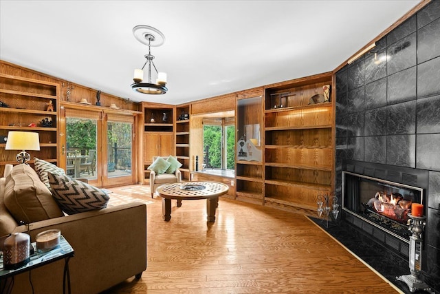 2865 Steeple Hill Rd, White Lake, MI 48383 - living room with wood finished floors, built in shelves, a fireplace, and a chandelier