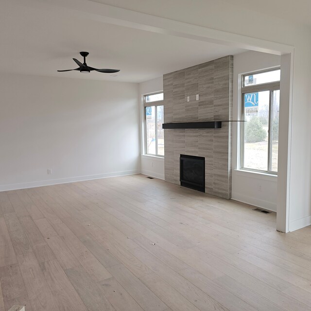 55834 Stewart Dr, Macomb, MI 48042 - unfurnished living room featuring baseboards, a fireplace, plenty of natural light, and ceiling fan