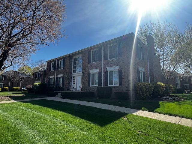 view of front of home with a chimney and a front yard