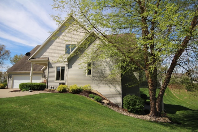 view of property exterior featuring a lawn, a garage, and concrete driveway