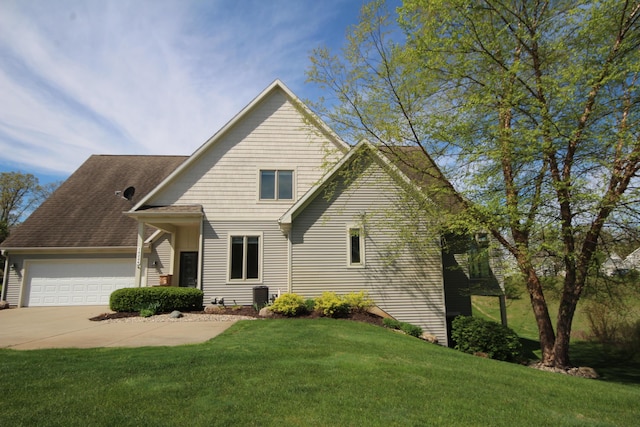 traditional home featuring a front yard, an attached garage, central AC unit, and driveway