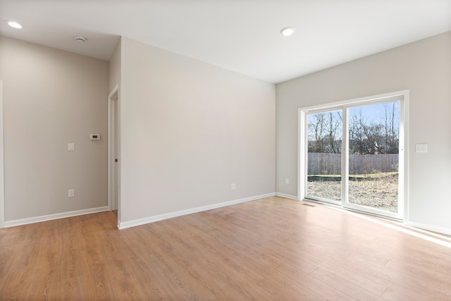 spare room with light wood finished floors, baseboards, and recessed lighting