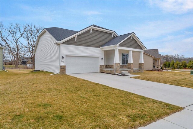 craftsman house featuring stone siding, driveway, a garage, and a front yard