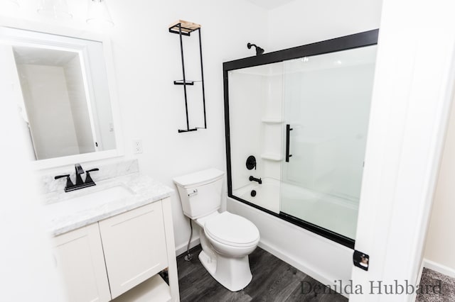 11724 N Satterlee Rd, Lakeview, MI 48850 - bathroom with vanity, toilet, combined bath / shower with glass door, wood finished floors, and baseboards