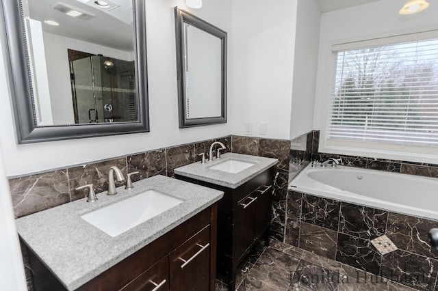 11724 N Satterlee Rd, Lakeview, MI 48850 - bathroom featuring marble look tiles, two vanities, and a garden tub