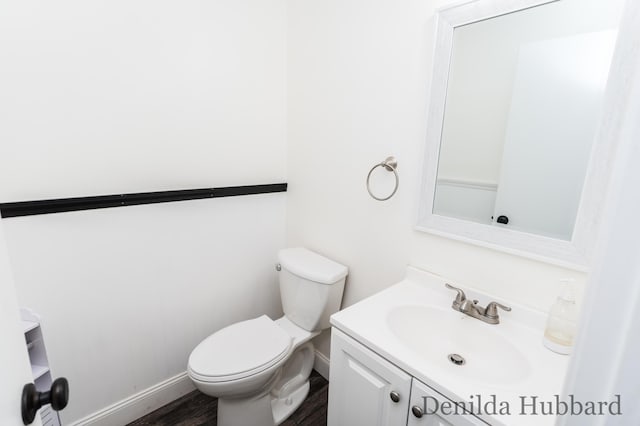 11724 N Satterlee Rd, Lakeview, MI 48850 - bathroom with vanity, toilet, baseboards, and wood finished floors