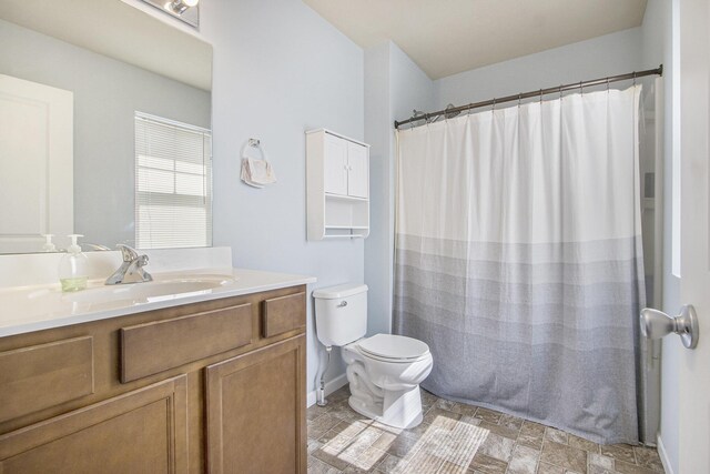 bathroom with baseboards, a shower with shower curtain, toilet, and vanity
