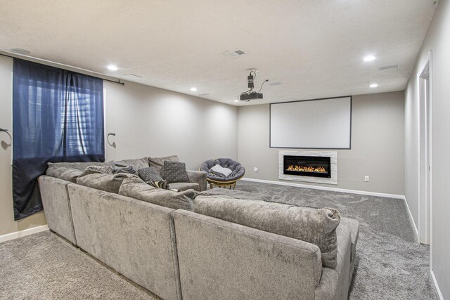 carpeted cinema with baseboards, visible vents, recessed lighting, and a glass covered fireplace