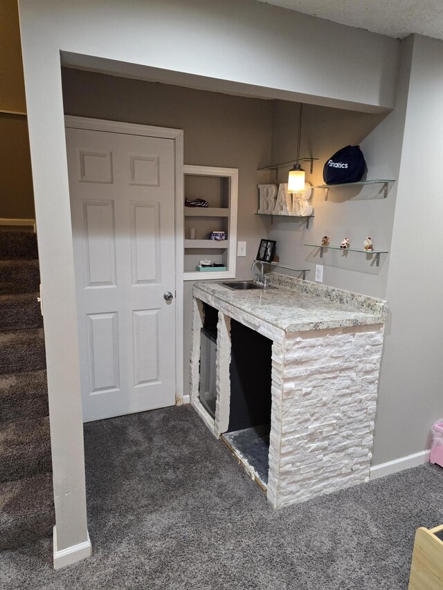 kitchen with light countertops, open shelves, baseboards, carpet floors, and a sink