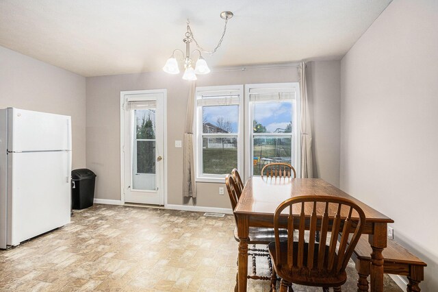 dining room with baseboards, visible vents, and a chandelier