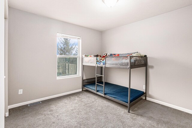 unfurnished bedroom featuring carpet flooring, baseboards, and visible vents