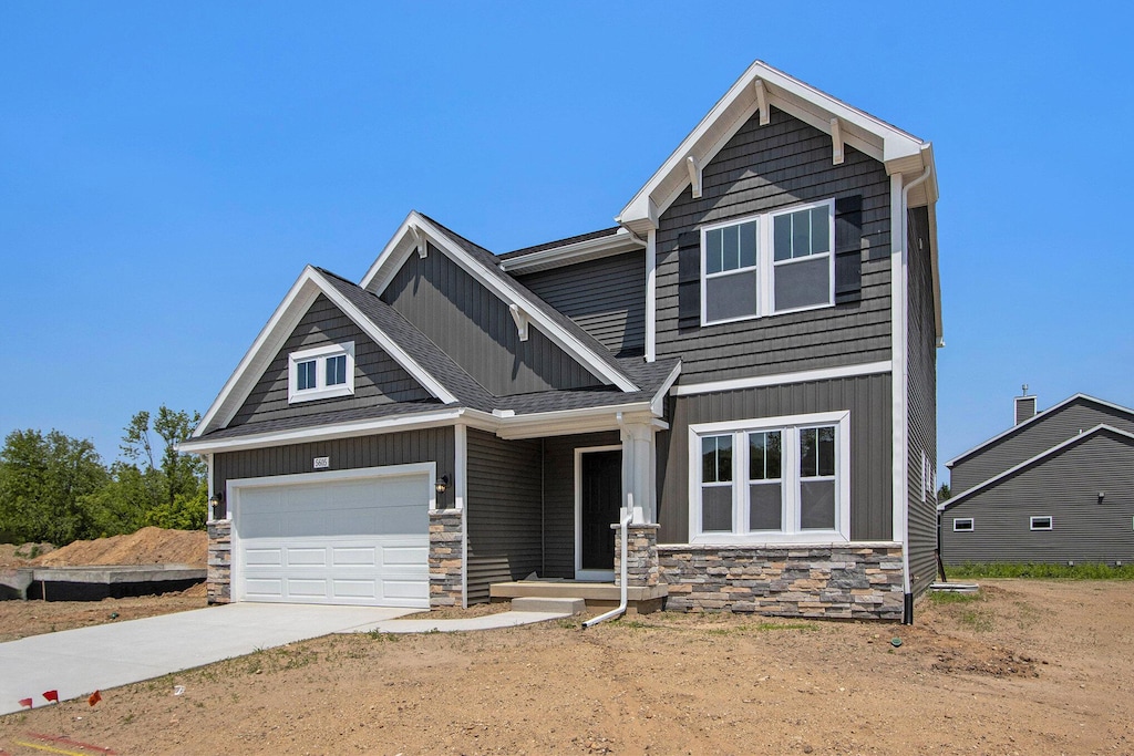 5605 Paxton Ct, Portage, MI 49024 - craftsman inspired home with stone siding, driveway, board and batten siding, and a garage