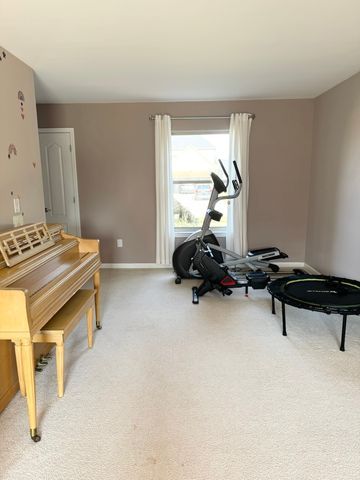 workout area featuring baseboards and light carpet