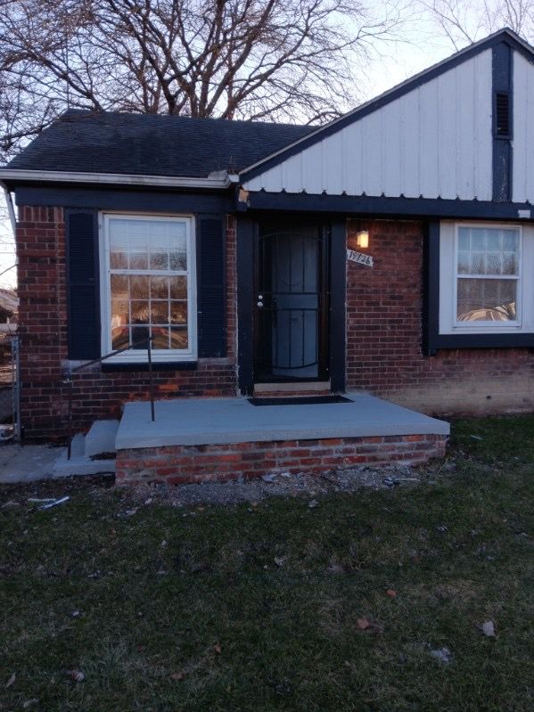 19726 Moross Rd, Detroit, MI 48224 - property entrance with brick siding and a lawn