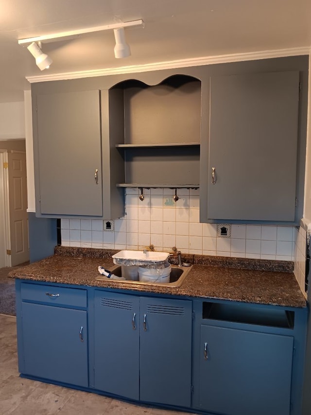 19726 Moross Rd, Detroit, MI 48224 - kitchen featuring dark countertops, blue cabinets, and decorative backsplash