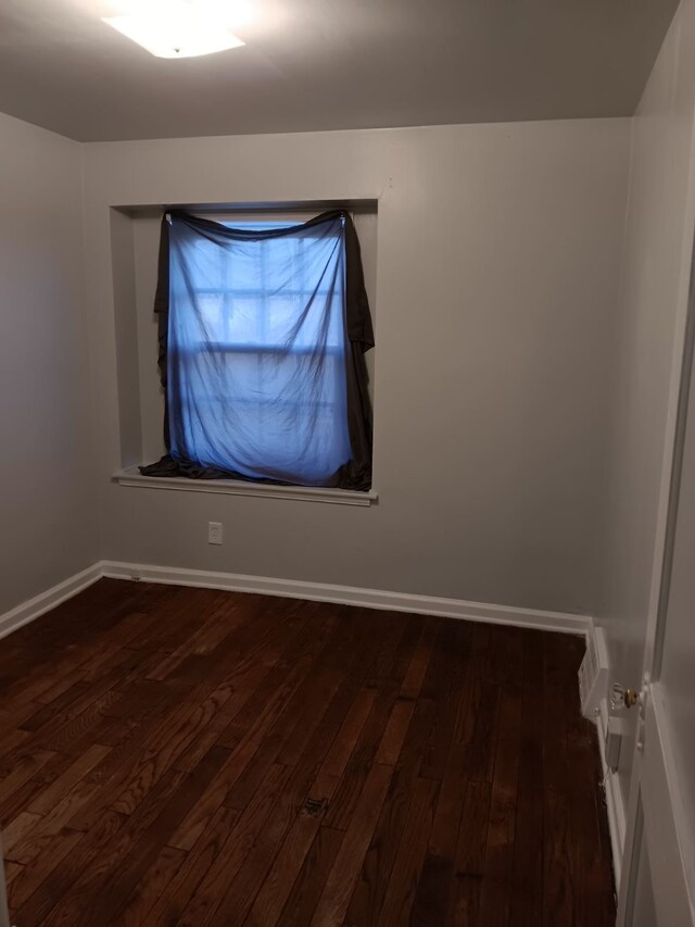 19726 Moross Rd, Detroit, MI 48224 - unfurnished room with baseboards and dark wood finished floors