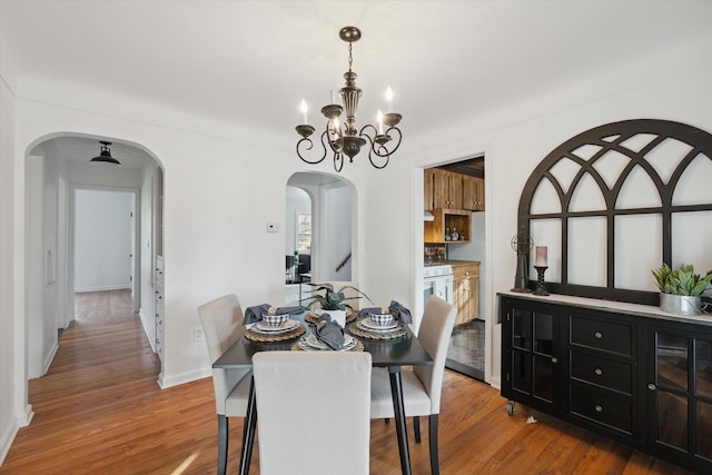 21124 Thorofare Rd, Grosse Ile, MI 48138 - dining space featuring baseboards, wood finished floors, arched walkways, and a notable chandelier