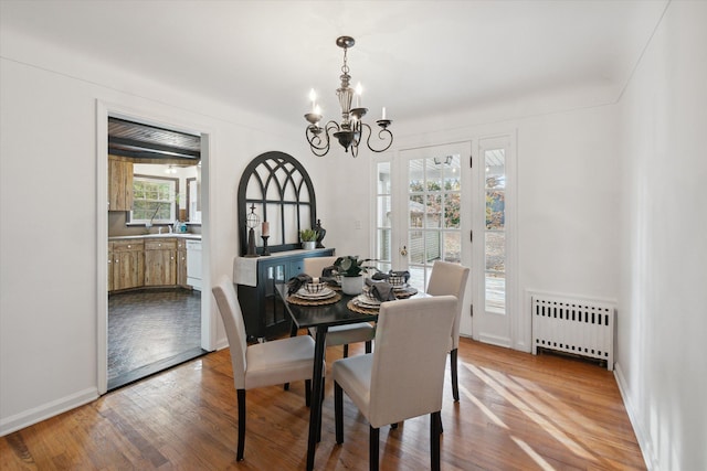 21124 Thorofare Rd, Grosse Ile, MI 48138 - dining space with a chandelier, radiator heating unit, baseboards, and wood finished floors