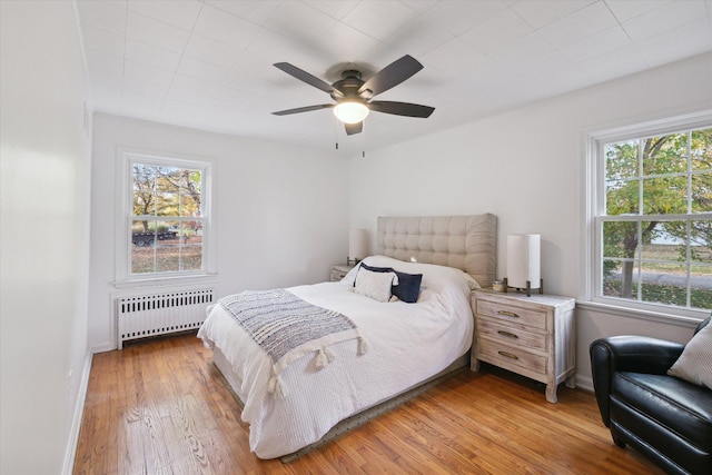 21124 Thorofare Rd, Grosse Ile, MI 48138 - bedroom with radiator, baseboards, wood finished floors, and multiple windows