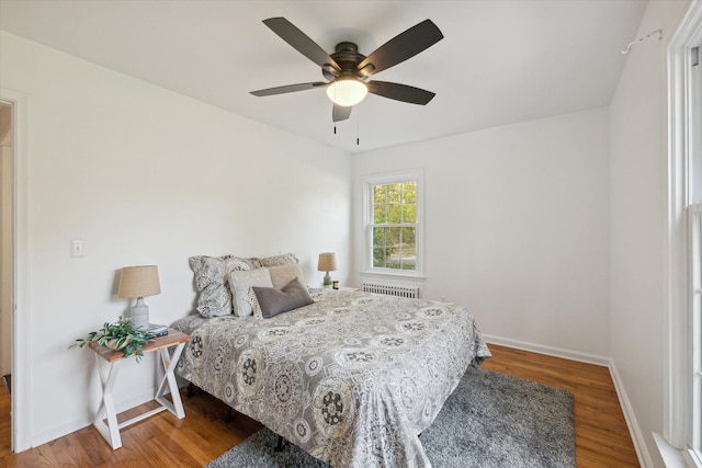 21124 Thorofare Rd, Grosse Ile, MI 48138 - bedroom with radiator heating unit, baseboards, a ceiling fan, and wood finished floors