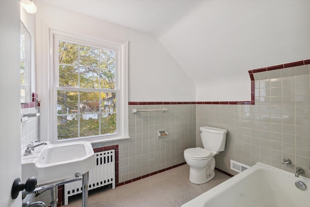 21124 Thorofare Rd, Grosse Ile, MI 48138 - full bathroom with vaulted ceiling, a tub to relax in, tile walls, toilet, and visible vents