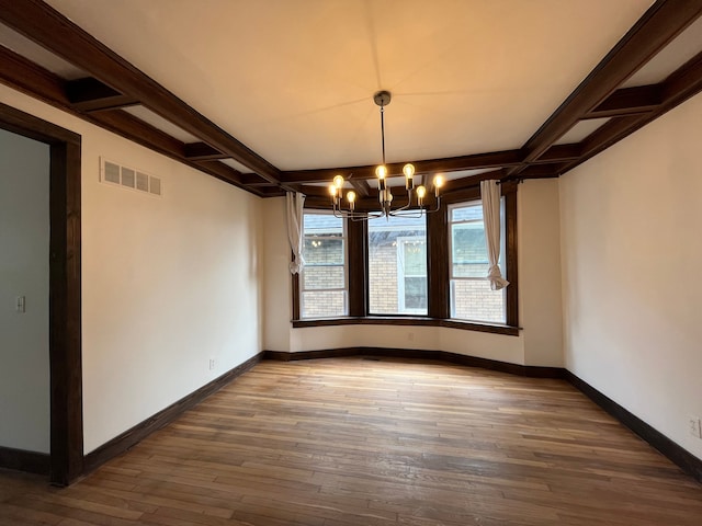 2563 Canton St, Detroit, MI 48207 - unfurnished dining area with an inviting chandelier, hardwood / wood-style flooring, coffered ceiling, and visible vents