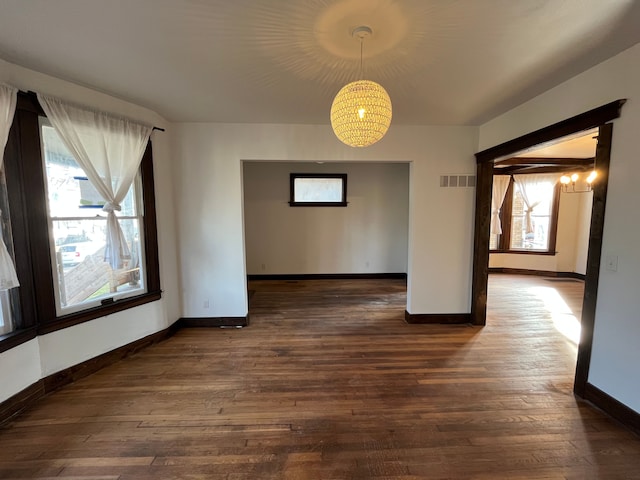 2563 Canton St, Detroit, MI 48207 - unfurnished room featuring baseboards, visible vents, dark wood-type flooring, and an inviting chandelier