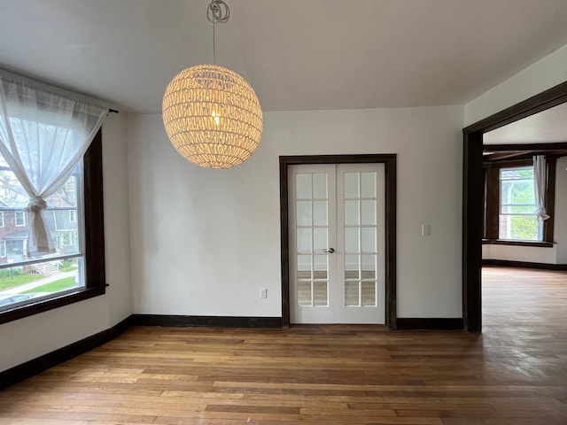 2563 Canton St, Detroit, MI 48207 - unfurnished dining area featuring baseboards, wood finished floors, french doors, and a notable chandelier