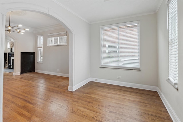 5784 Whittier St, Detroit, MI 48224 - interior space featuring ornamental molding, arched walkways, light wood-style flooring, and a chandelier