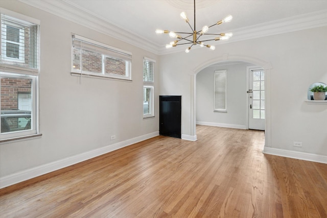 5784 Whittier St, Detroit, MI 48224 - unfurnished dining area with an inviting chandelier, light wood-style flooring, baseboards, ornamental molding, and arched walkways