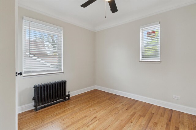 5784 Whittier St, Detroit, MI 48224 - empty room featuring radiator heating unit, a ceiling fan, light wood-style flooring, and plenty of natural light