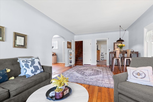 3440 Crandall Rd, Howell, MI 48855 - living room with arched walkways, wood finished floors, stairs, and healthy amount of natural light