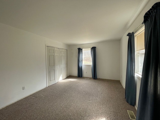 spare room with light colored carpet and visible vents