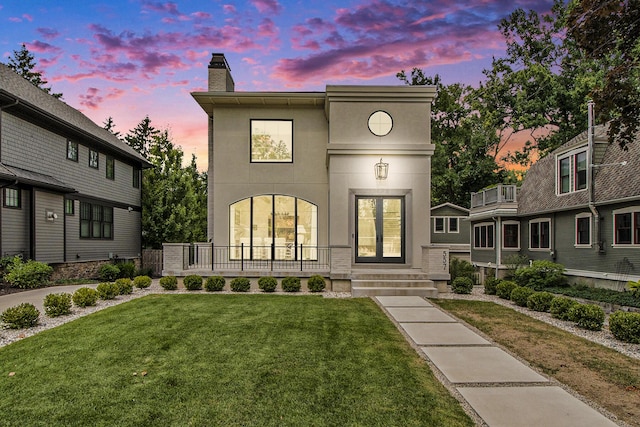 557 Greenwood Ave SE, East Grand Rapids, MI 49506 - view of front facade featuring a lawn, a chimney, and stucco siding