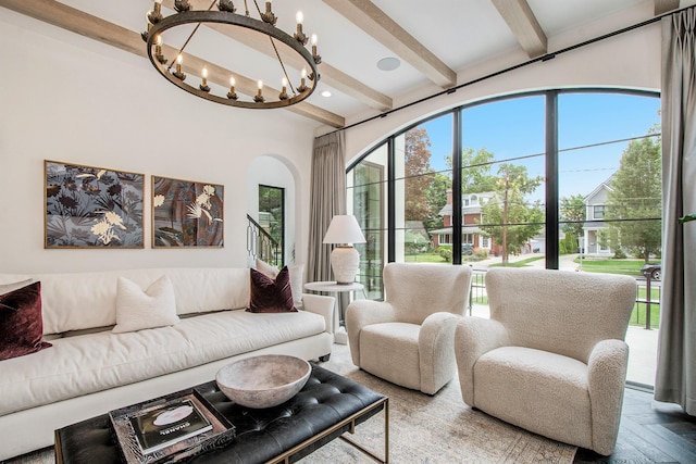 557 Greenwood Ave SE, East Grand Rapids, MI 49506 - living room featuring beamed ceiling, arched walkways, and an inviting chandelier
